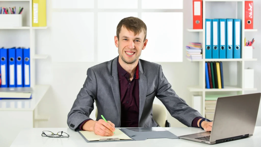 professional-businessman-smiling-at-desk-in-modern-office-workspace