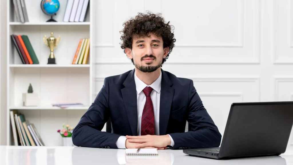 young-professional-businessman-curly-hair-office-desk-laptop-workspace